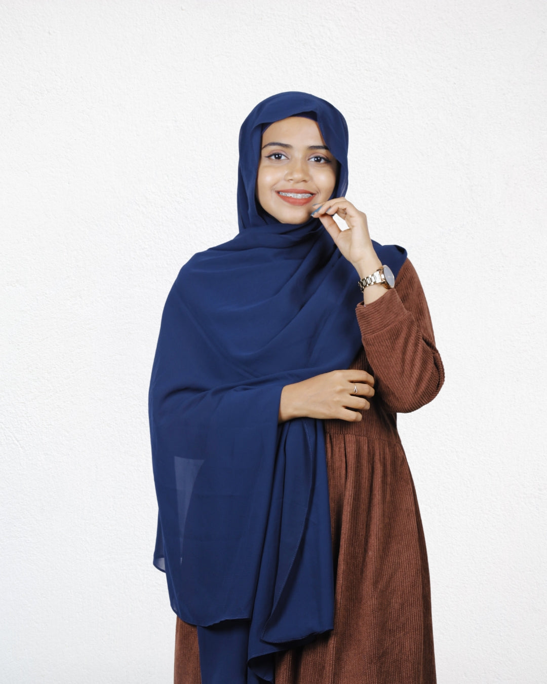 A woman showing off a navy blue chiffon scarf, perfect for a clean, classic look.