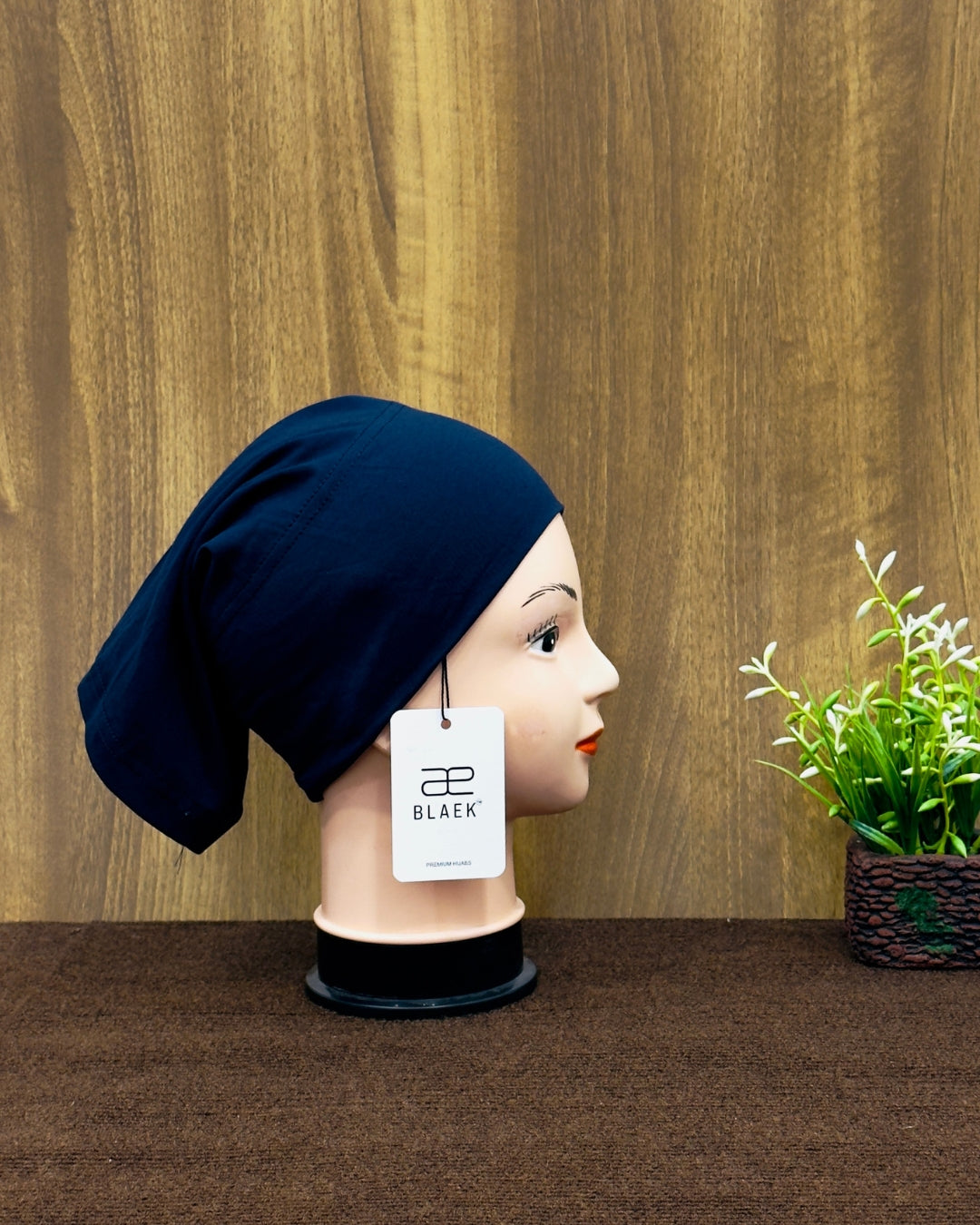 Side view of a navy blue tube cap on mannequin.