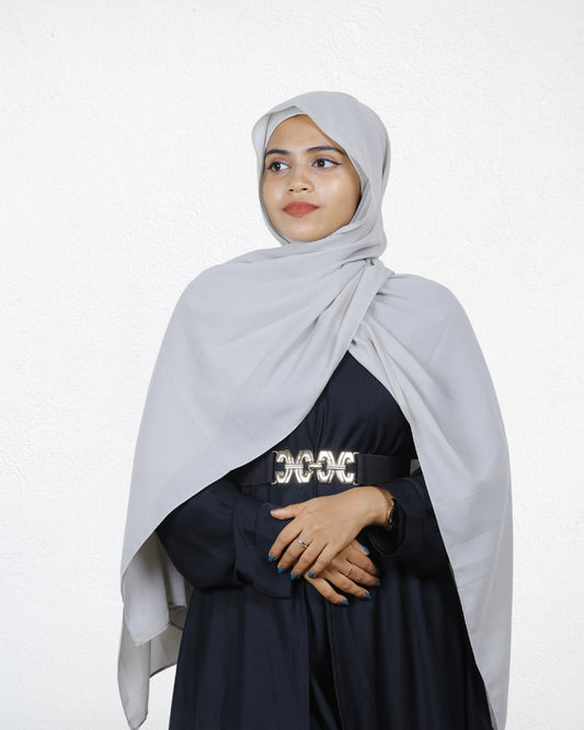 A woman showcasing a silver chiffon scarf, adding a sophisticated glow to her look.