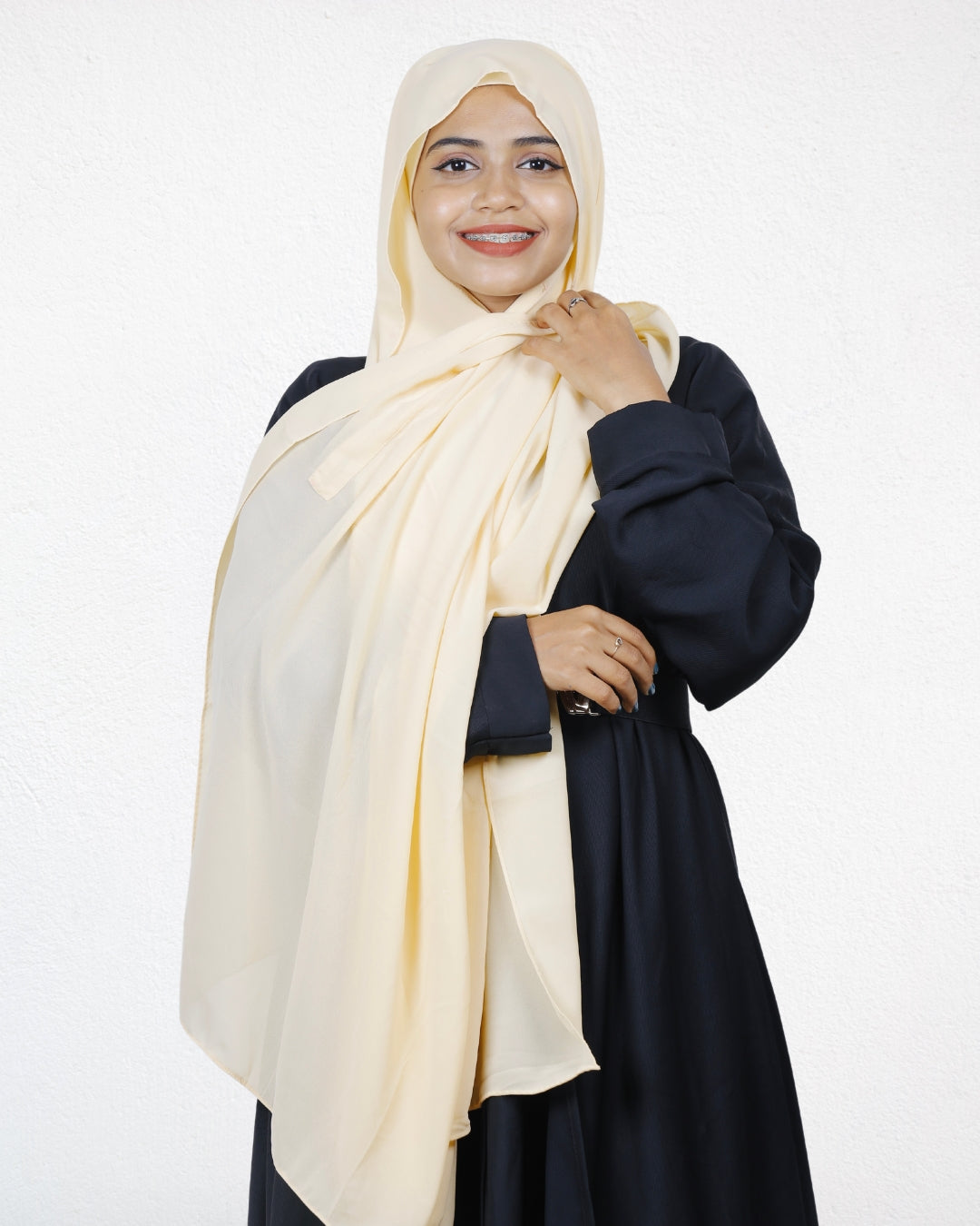 A woman wearing a vanilla chiffon scarf, giving her outfit a soft, warm vibe.